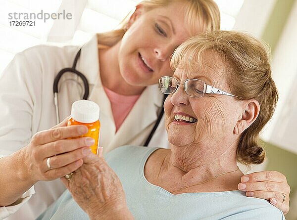 Glückliche Ärztin oder Krankenschwester  die einer älteren erwachsenen Frau ein Rezept erklärt