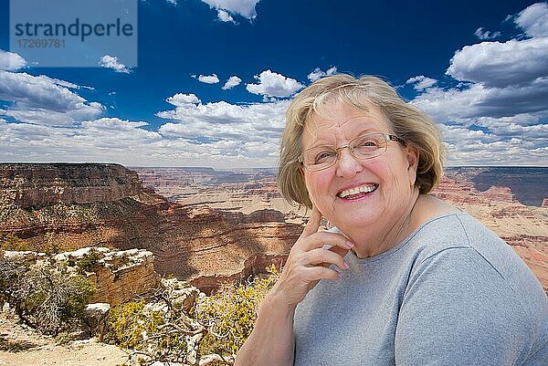 Glückliche ältere Frau posiert am Rande des Grand Canyon