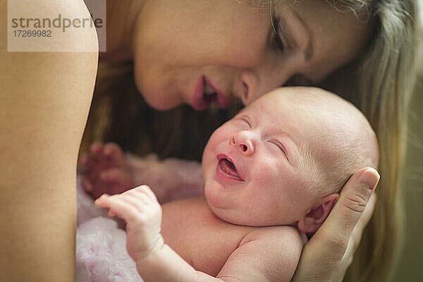 Junge kaukasische schöne Mutter hält ihr kostbares neugeborenes Baby Mädchen