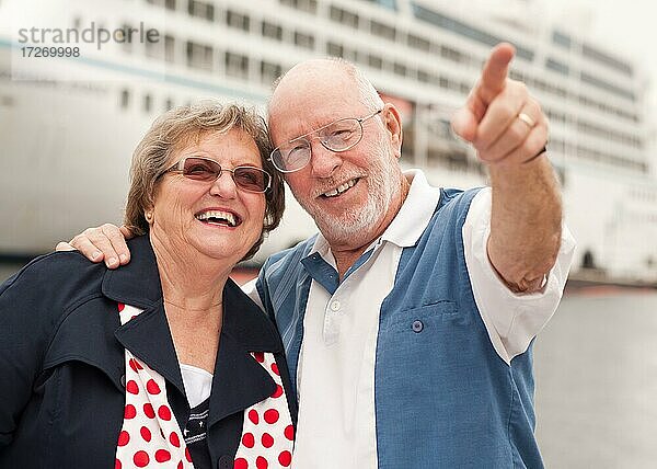Älteres Paar an Land vor einem Kreuzfahrtschiff im Urlaub