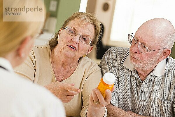 Arzt oder Krankenschwester erklärt einem aufmerksamen Seniorenpaar verschreibungspflichtige Medikamente
