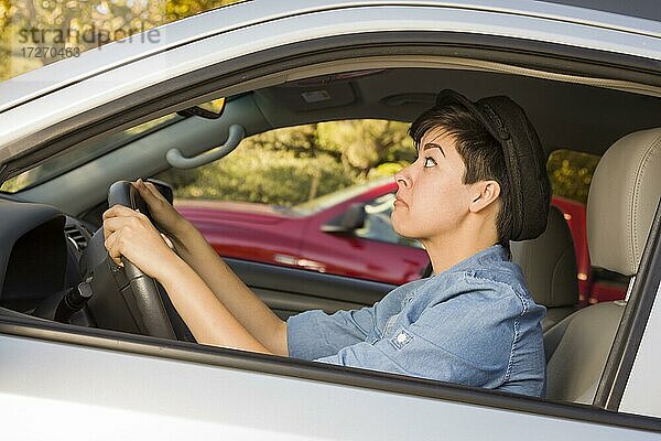 Sehr gestresste gemischtrassige Frau beim Autofahren und im Verkehr