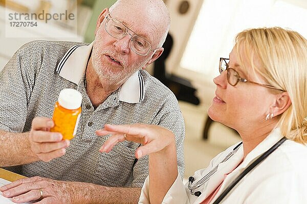 Arzt oder Krankenschwester erklärt verschreibungspflichtige Medikamente an aufmerksamen älteren Mann