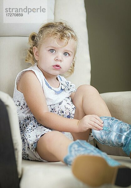 Adorable blonde Haare blauäugige kleine Mädchen setzen auf Cowboy-Stiefel