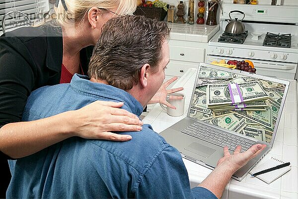 Paar in der Küche mit Laptop  um Geld zu verdienen oder zu gewinnen. Bildschirm kann leicht für Ihre eigene Nachricht oder Bild verwendet werden
