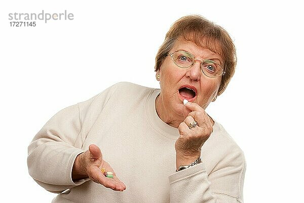 Attraktive ältere Frau nimmt Pillen vor weißem Hintergrund