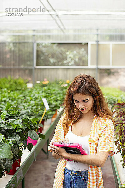 Geschäftsfrau  die ein digitales Tablet benutzt  während sie in einem Gartencenter steht