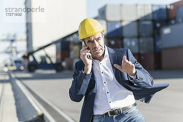 Porträt eines Geschäftsmannes  der in einem Industriegebiet telefoniert