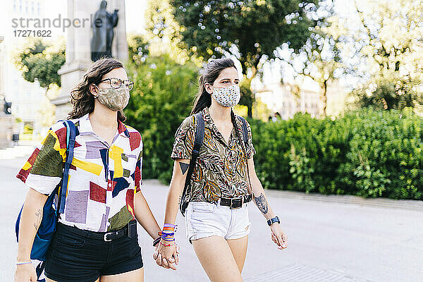 Lesbisches Paar mit Gesichtsschutzmaske auf der Straße in der Stadt
