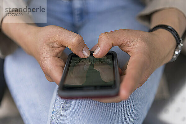 Hände einer Frau  die eine Textnachricht auf einem Smartphone schreibt