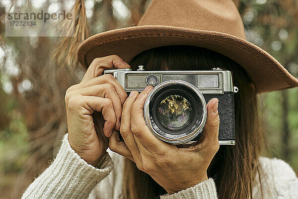 Frau fotografiert durch eine alte Kamera im Wald