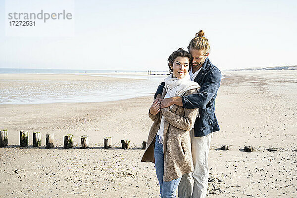 Romantisches junges Paar  das sich am Strand umarmt