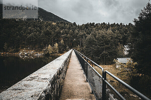Schmale Brücke über den Alpensee im Winter