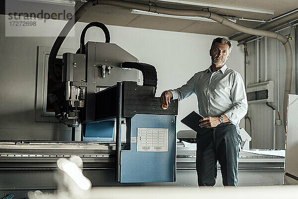 Männlicher Ingenieur mit digitalem Tablet an einer Produktionsanlage in einer Fabrik