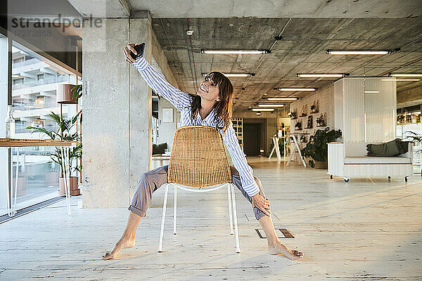 Reife Frau  die ein Selfie mit ihrem Smartphone macht  während sie zu Hause sitzt