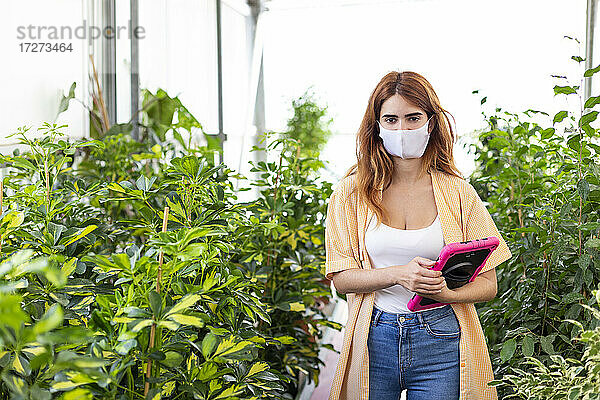 Geschäftsfrau  die ein digitales Tablet hält  während sie in einem Gartencenter steht