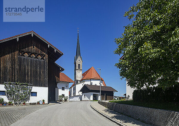 Deutschland  Bayern  Saaldorf-Surheim  Straße vor einer Kirche in einer ländlichen Stadt