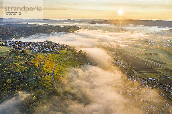 Deutschland  Baden Württemberg  Remstal  Drohnenansicht einer Stadt auf dem Land bei nebligem Sonnenaufgang