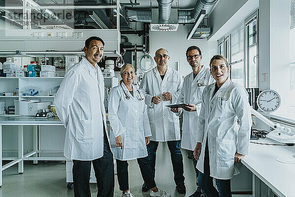 Selbstbewusstes Wissenschaftlerteam steht im Labor zusammen