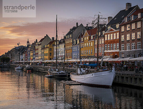 Dänemark  Kopenhagen  Boote an der Nyhavn-Promenade in der Abenddämmerung mit einer Reihe von historischen Stadthäusern im Hintergrund