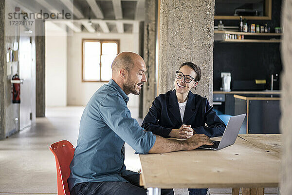 Geschäftsleute  die im Büro mit ihrem Laptop diskutieren