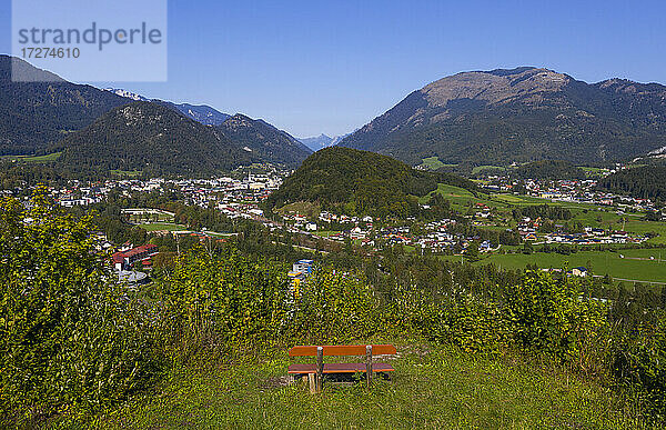 Leere Bank inmitten von Pflanzen nahe der Stadt an einem sonnigen Tag  Salzkammergut  Österreich