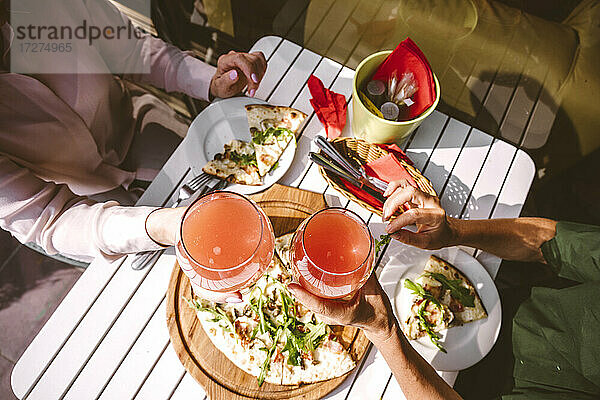 Freunde stoßen in einem Restaurant mit einem Fruchtgetränk an