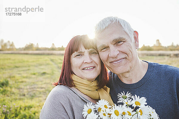 Lächelndes Seniorenpaar mit Kamillenblüten