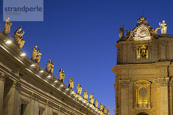 Beleuchtete Heiligenstatuen auf dem Petersdom gegen den klaren blauen Himmel bei Nacht  Vatikanstadt  Rom  Italien