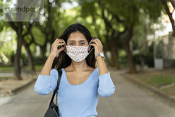 Schöne Frau mit Gesichtsschutzmaske während COVID-19