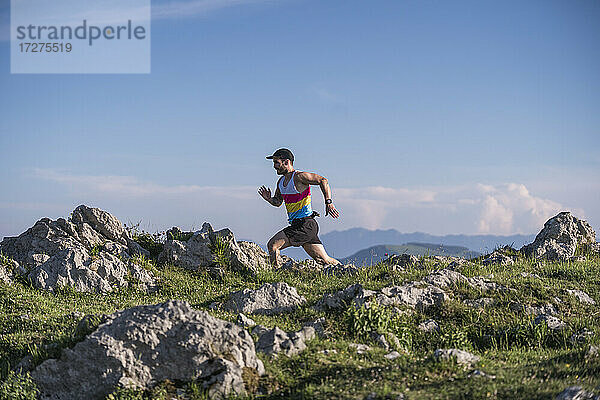 Sportler läuft auf Berg gegen klaren Himmel