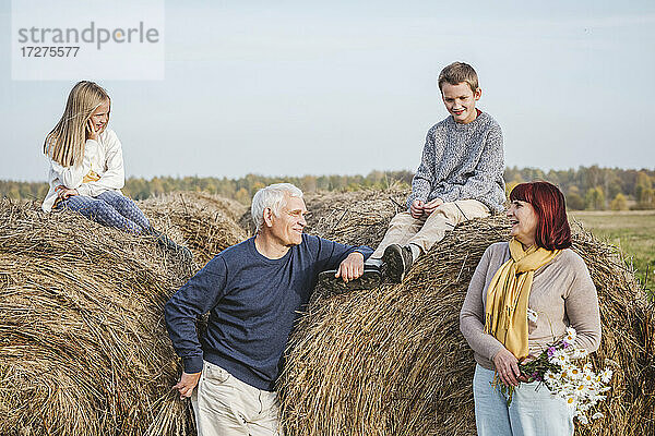Großeltern mit Enkelkindern auf Heuballen sitzend