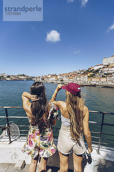 Freundinnen schauen auf den Fluss Douro  während sie ein Wochenende in der Stadt Porto  Portugal  verbringen