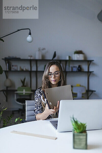 Kreative Geschäftsfrau mit Stoffmustern am Schreibtisch im Büro sitzend