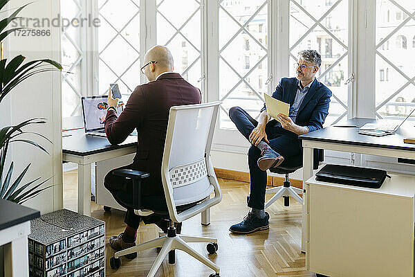 Geschäftsleute arbeiten am Schreibtisch vor dem Fenster im Büro