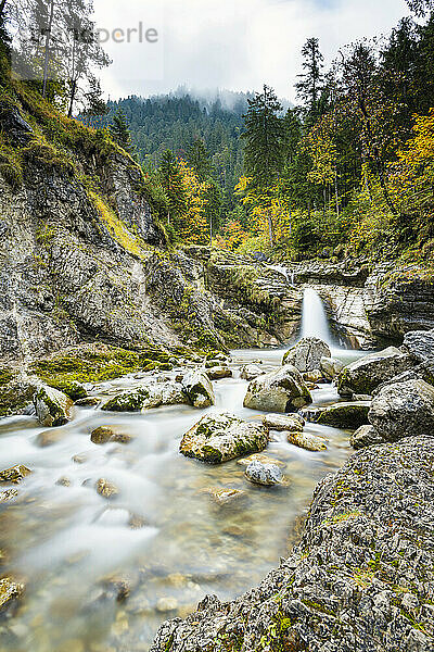 Wasserfall und Bach in Herbstlandschaft