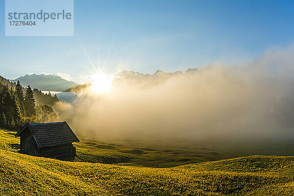 Dichter Nebel umhüllt den Geroldsee bei Sonnenaufgang im Herbst