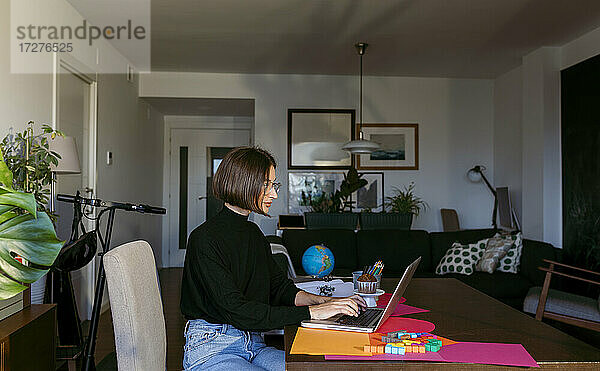 Geschäftsfrau  die konzentriert am Laptop arbeitet  während sie zu Hause sitzt