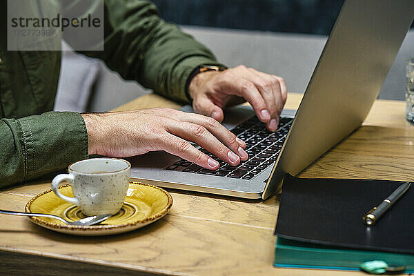 Geschäftsmann arbeitet am Laptop  während er im Café sitzt