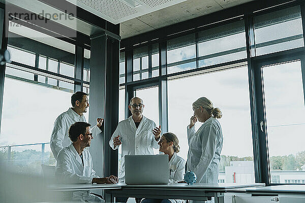Ärzte und Wissenschaftler diskutieren im Stehen im Büro