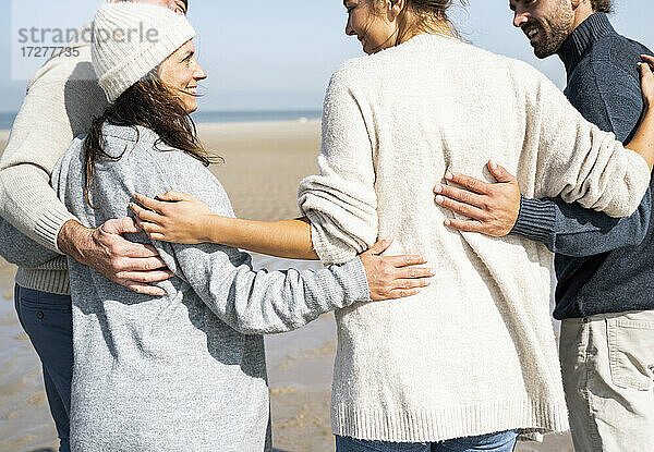 Familie stehend mit Arm um am Strand