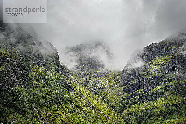 Tief hängende Wolken über dem Bach in Glen Coe