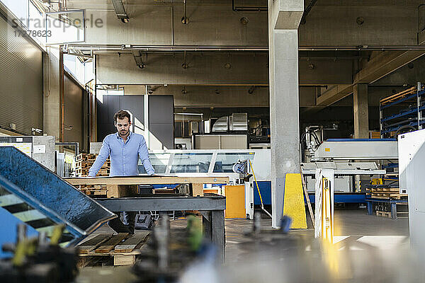 Geschäftsmann bei der Arbeit an einem Tisch in einer Fabrik
