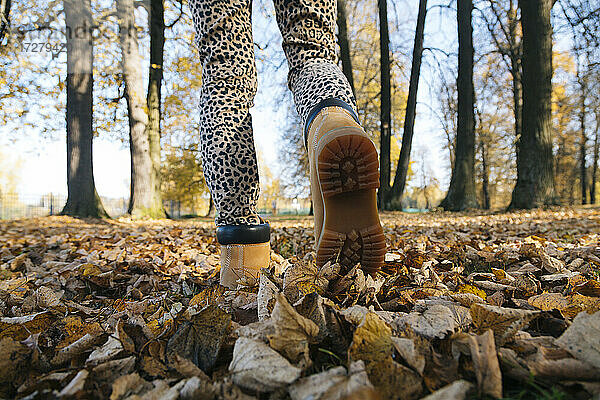 Füße einer Frau  die in einem öffentlichen Park spazieren geht
