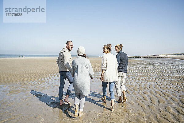 Glückliche Familie beim gemeinsamen Spaziergang am Strand