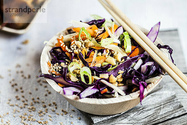 Nahaufnahme einer Schüssel mit vietnamesischem Krautsalat und Stäbchen auf dem Tisch