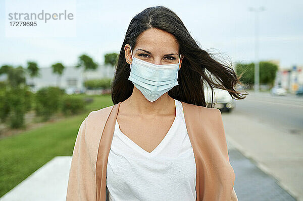 Junge Frau mit Gesichtsschutzmaske auf der Straße