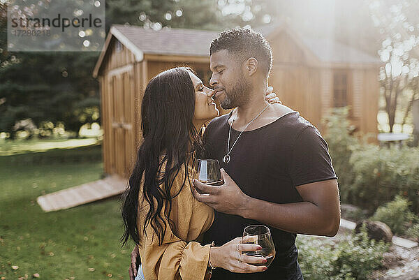 Paar hält Weinglas während Romantik stehen im Hinterhof zu tun