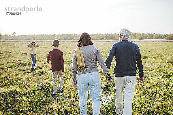 Großeltern verbringen am Wochenende Zeit mit ihren Enkeln auf dem Feld
