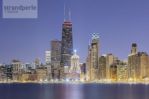 Beleuchtete Ansicht von 875 North Michigan Avenue (John Hancock Center) umgeben von Wolkenkratzern in der Abenddämmerung  Chicago  USA